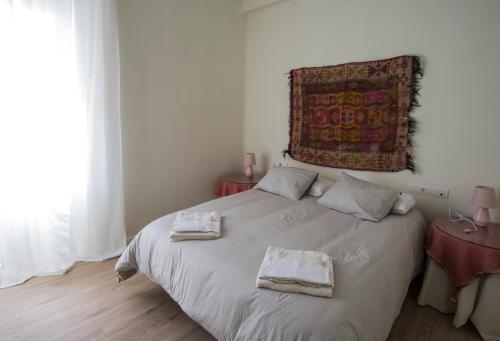 马拉加Muelle 18的一间卧室配有一张床,上面有两条毛巾