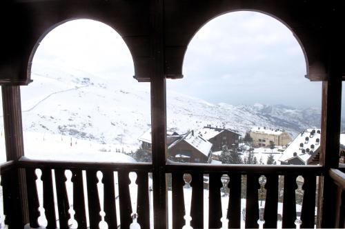 塞拉内华达GHM帝皇酒店的窗户享有雪覆盖的山景。
