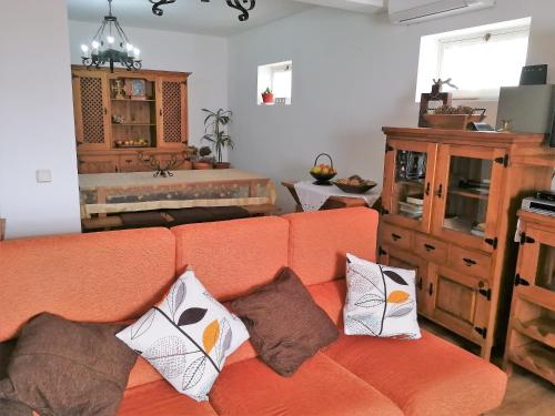 Capelo火山乡村民宿旅馆的客厅里配有带枕头的橙色沙发