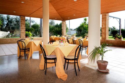 斯佩基亚萨兰托酒店的餐厅设有桌椅和黄色桌布
