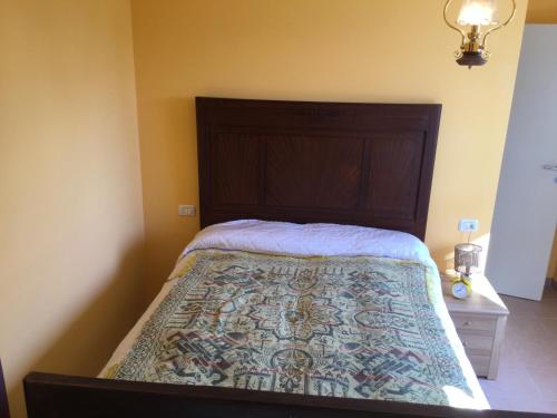 PalazzoCasa Luisa的一间卧室配有一张带木制床头板的床