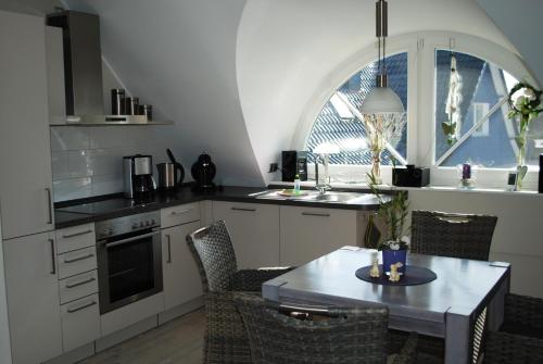 青斯特Zingst的厨房配有桌椅、桌子和窗户。