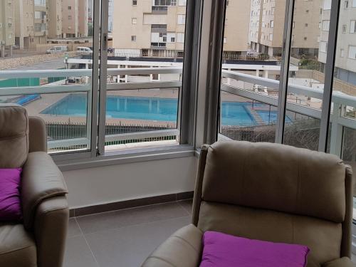 内坦亚Nitza Boutique Apartment Kosher的享有泳池景致的客房内的2把椅子