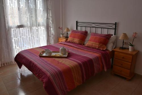 厄尔梅达诺El Medano Playa del Cabezo的一间卧室配有一张床,上面放着一个食物托盘