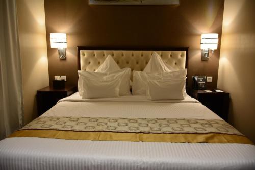 阿可贺巴豪姆因公寓式酒店的卧室配有带白色枕头的大床