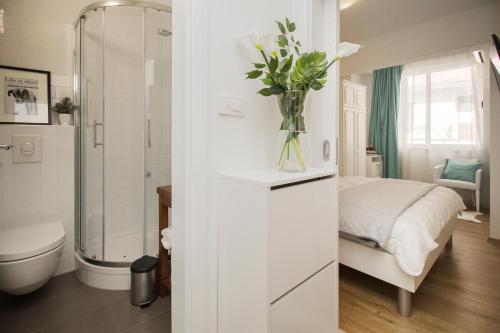 马卡尔斯卡Apartmani Leo-Marin的白色的浴室,配有一张床和花瓶