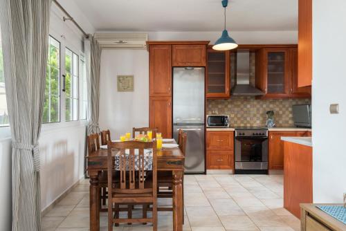 斯卡拉Villa AnnaMaria的厨房配有木制橱柜和桌椅
