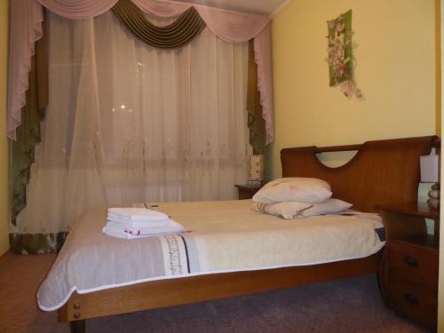 特鲁斯卡韦茨Мини-отель "Ольга"的一间卧室配有一张带白色床单的床和一扇窗户。