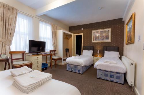 布莱克浦山脉酒店的酒店客房设有两张床、一张桌子和一台电视。