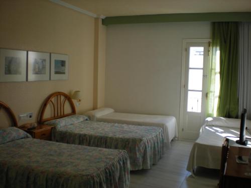 维拉卡莫纳阳台酒店的酒店客房设有两张床和窗户。