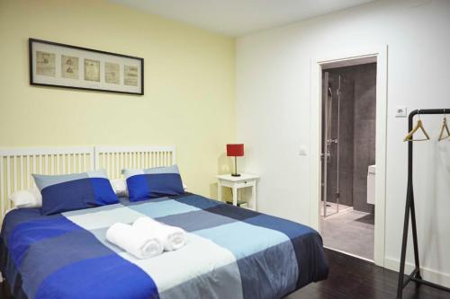 马德里Apartamento Principe Pio的卧室配有蓝色和白色的床和毛巾