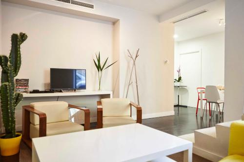 马德里Apartamento Principe Pio的客厅配有椅子和墙上的电视