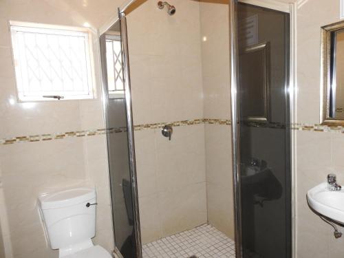 阿曼济姆托蒂沙龙玫瑰旅馆的带淋浴、卫生间和盥洗盆的浴室