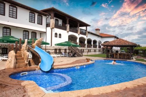 斯塔罗塞尔Wine & Spa Complex Starosel的房屋前带滑梯的游泳池