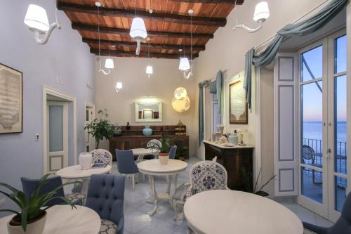 特罗佩阿Palazzo Mottola Tropea的配有桌椅的海景客房