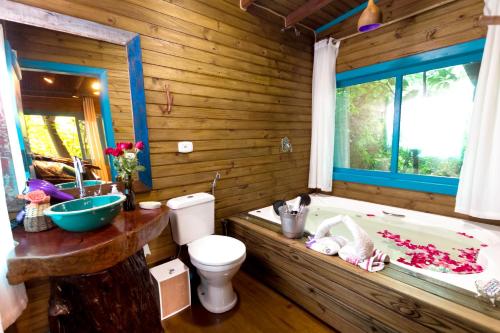 大普拉亚Pousada Refúgio das Montanhas的木制浴室设有浴缸、卫生间和水槽