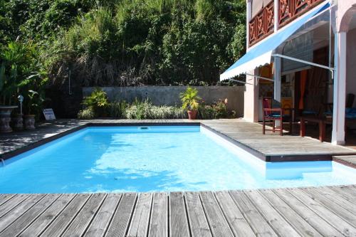 三河市BEL Z 'IGUANE的一座带木甲板的游泳池,位于一座房子旁边