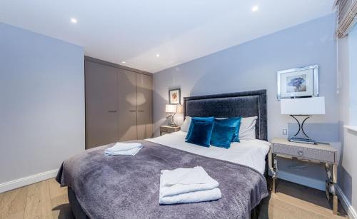 伦敦Lux St James Park Apartment Central London FREE WIFI by City Stay Aparts London的一间卧室配有一张带蓝色枕头的大床