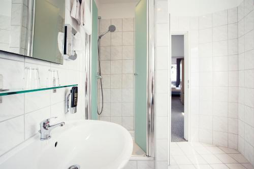 蒙塔鲍尔莱恩古斯酒店的白色的浴室设有水槽和淋浴。