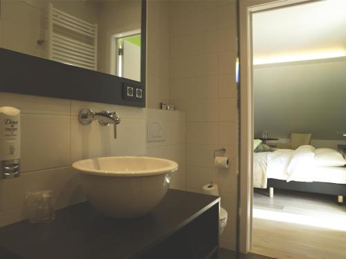 兰登艾欧农皓福酒店的一间带水槽和镜子的浴室以及一张床