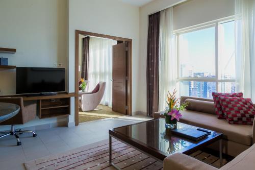 阿布扎比Grand Millennium Al Wahda Hotel and Executive Apartments Abu Dhabi的带沙发和大窗户的客厅