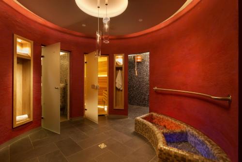 什平德莱鲁夫姆林Wellness Hotel Grand的大堂设有红色的墙壁和走廊上的沙发
