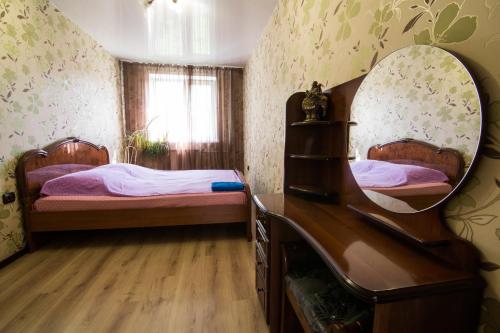 新库兹涅茨克Apartments on Kirova 76的一间卧室配有两张床和镜子