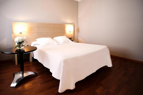 费罗尔瓦伦西亚酒店的一张大白色的床,位于带桌子的房间