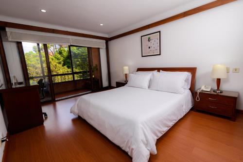 波哥大普勒尼图德公寓旅行者酒店的卧室设有白色的床和大窗户