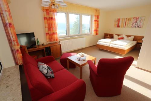 TreffurtHotel Waldblick的客厅配有红色椅子和红色沙发