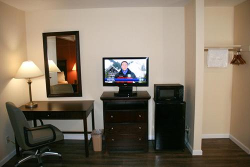 伍德兰奥克斯山谷林地酒店的客房设有电视、书桌和镜子