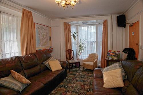 多尔盖罗常春藤旅馆的客厅配有真皮沙发和椅子