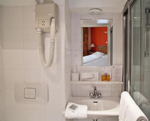 巴黎多尼克卢浮宫酒店的白色的浴室设有水槽和镜子