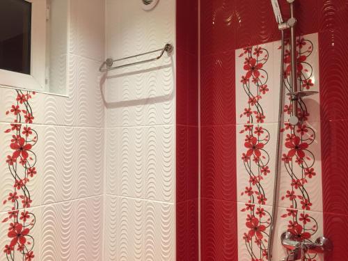 戈采代尔切夫Elenite Guesthouse的配有红色和白色淋浴帘的淋浴