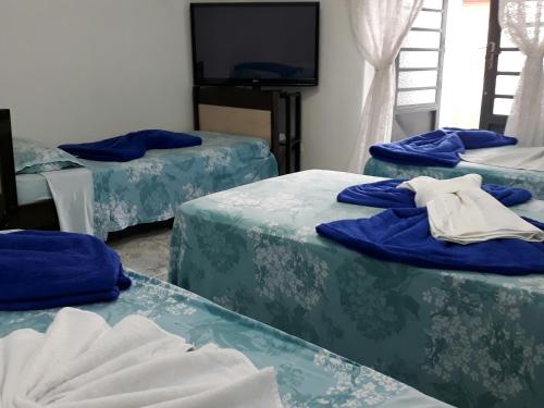 圣保罗Hospedaria Cambuci Unidade Ipiranga的带三张床和蓝色床单的客房