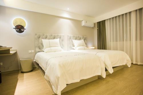 阳朔白玉兰阳朔西街酒店的卧室配有一张带白色床单和枕头的大床。