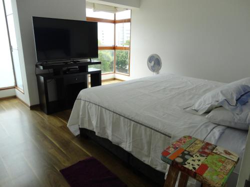 利马San Borja, bello apartamento的一间卧室配有一张床和一台平面电视