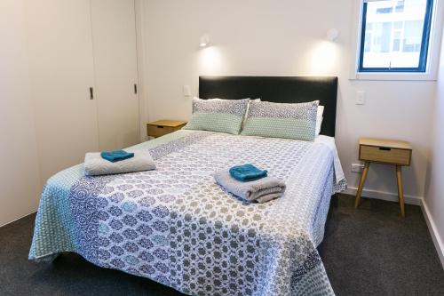 纳尔逊Riverwalk Apartments的一间卧室配有一张床,上面有两条毛巾