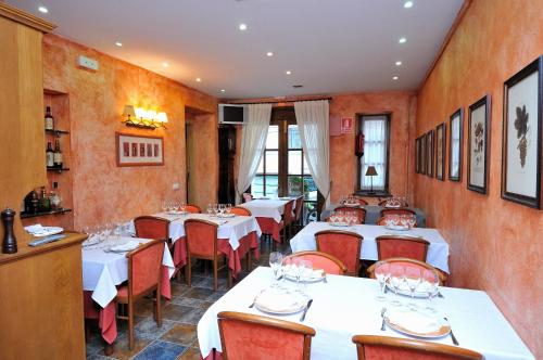利维亚美茨芳达酒店的一间设有白色桌子和红色椅子的餐厅
