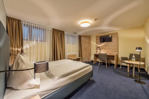 科隆温莎酒店的配有一张床和一张书桌的酒店客房