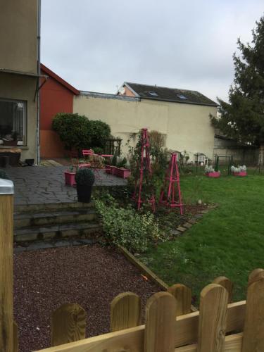 阿布维尔La Vie est Belle的后院设有带围栏和房屋的花园
