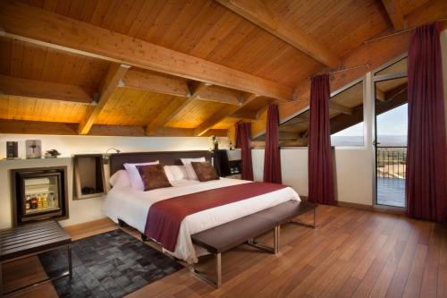 拉瓜迪亚埃古伦乌加特酒店的一间卧室设有一张大床和一个壁炉