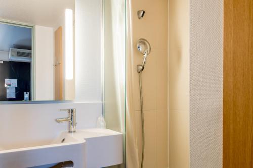 洛尔蒙B&B HOTEL Bordeaux Lormont的带淋浴、盥洗盆和镜子的浴室