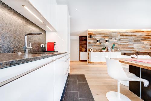 比尔塞贝格Appartement Zimba Blick by A-Appartments的厨房配有白色橱柜和带水槽的台面