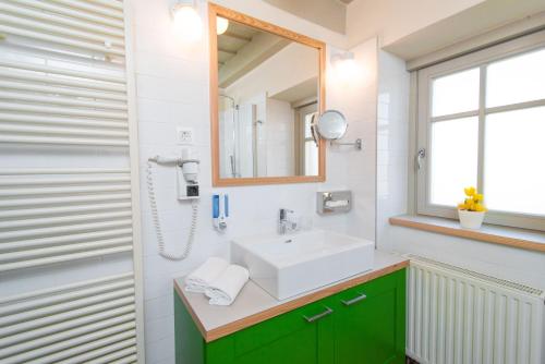赫维兹Kolping Holiday Resort的一间带水槽和镜子的浴室
