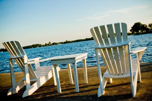 加纳诺克加纳诺​​克酒店及水疗中心的水边码头上的两把椅子和一张桌子