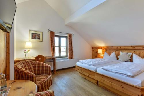 罗森海姆朱姆艾丁格维斯布劳兰德加斯特霍夫酒店的配有一张床和一把椅子的酒店客房