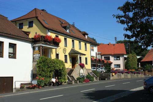 MottenHotel Gasthof zum Biber的街道边的黄色房子,花朵花