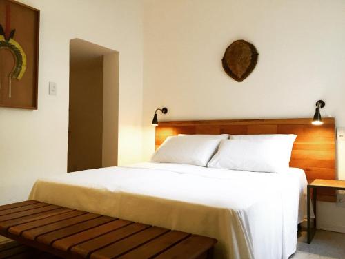 萨尔瓦多Viver Bahia Pousada的卧室配有白色大床和长凳