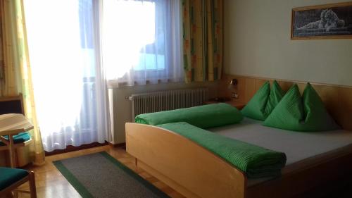 Sankt Lorenzen im LesachtalPension Anderlehof的一间卧室配有一张带绿色枕头的床。